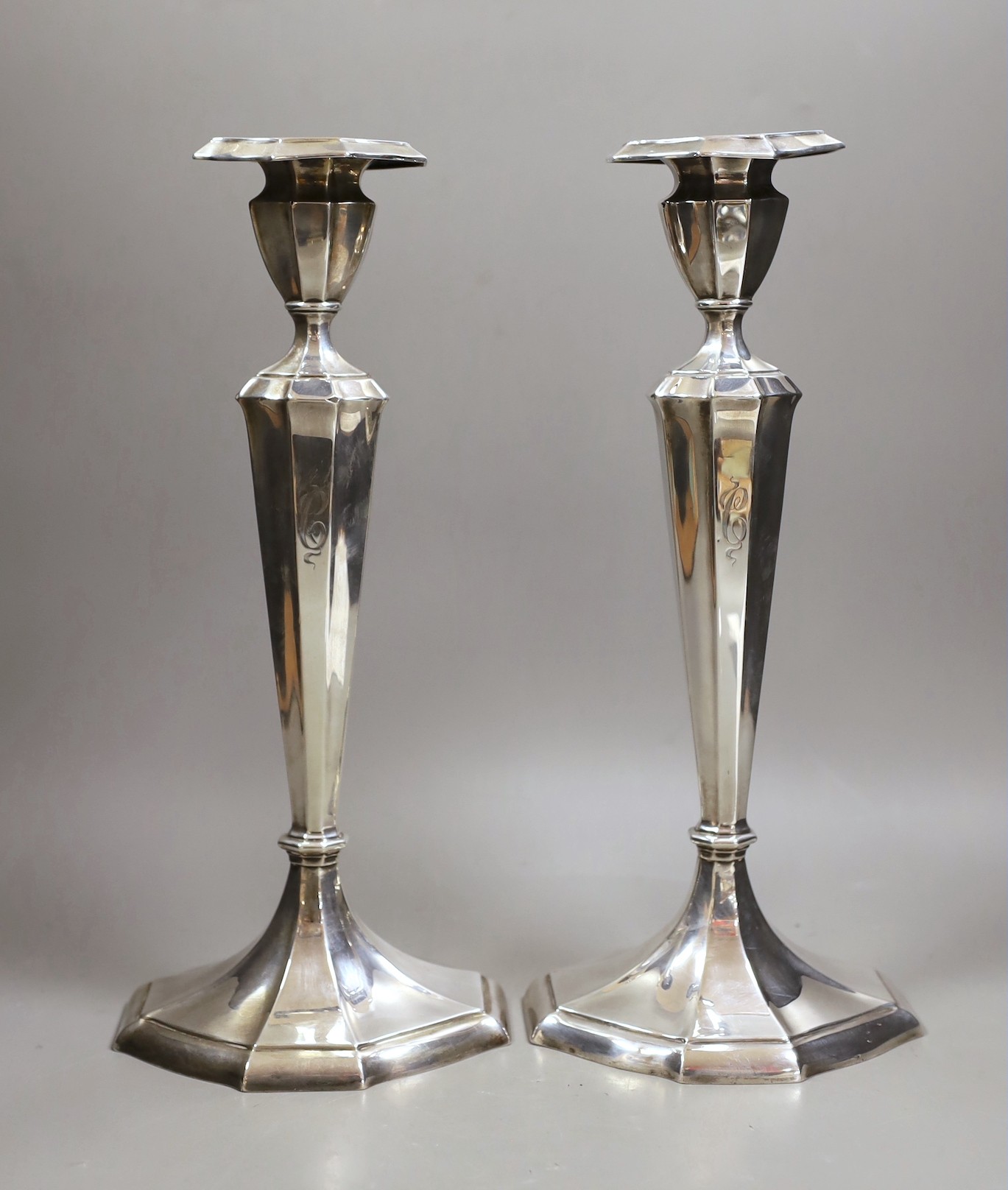 A pair of North American sterling candlesticks, with panelled stems and shaped oval bases, 34.1cm, weighted.